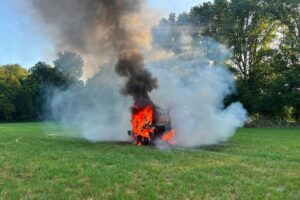 Feuerwehr löscht brennende Rundballenpresse an einer Zugmaschine auf einem Feld bei Menden-Halingen (Archiv).