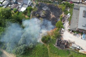 Feuerwehr Bochum löscht Vegetationsbrand in Wattenscheid: brennende Wiese und Sträucher, viele Einsatzkräfte.