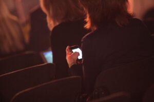 Geschäftsfrauen mit Smartphone (Archivfoto) – Fokus auf Frauen in Führungsrollen und Arbeitsbedingungen.