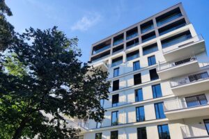 Junge Erwachsene vor Wohnblocks, symbolisierend das Wohnen bei den Eltern und Auszugsalter.