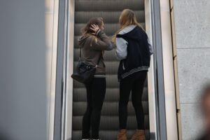 Junge Mädchen auf Rolltreppe, symbolisch für die gesellschaftlichen Herausforderungen und Sorgen der Bürger.