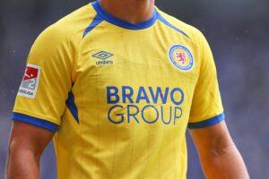 Eintracht Braunschweigs Spieler feiern das historische Wappen mit steigendem Löwen am Stadion.