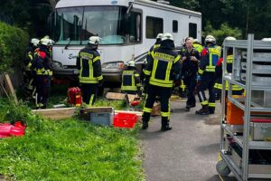Rettungskräfte befreien Person unter einem Wohnmobil mit Hebekissen in dramatischer Szene.