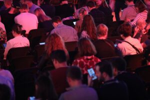 Junge Menschen mit Smartphones; Debatte über Social-Media-Verbot für Jugendliche und Regulierung der Plattformen.