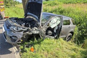Verunfallter Range Rover nach Frontalkollision auf der Hooksieler Landstraße, Rettungskräfte am Unfallort.