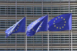 EU-Fahnen im Archiv, Hinweis auf Studie: kritische Rohstoffe für Batterien, Halbleiter und Verteidigung.