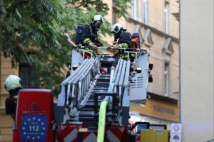 Feuerwehr löscht Brand in Wohnhaus, Rettungskräfte im Einsatz, dichten Rauch bekämpfend.