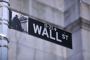 Straßenschild der Wall Street in New York, im Kontext uneinheitlicher US-Börsen- und Zinsnachrichten.