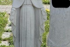 Eine gestohlene Madonna-Statue auf einem Friedhof in Eberhardzell, umgeben von Grabsteinen.