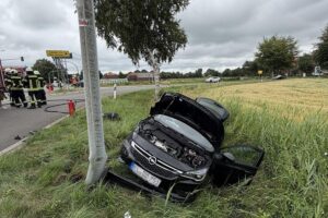 Zwei beschädigte Autos nach Frontalzusammenstoß, Feuerwehr sichert Unfallstelle und hilft Verletzten.