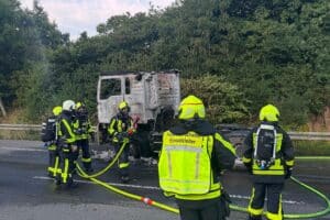 Vollbrand eines Sattelzug-Lkw auf der Autobahn A1, Feuerwehr löscht mit Einsatzfahrzeugen und Atemschutz (Archiv).