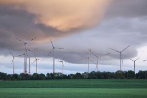 Windräder im stürmischen Wetter, mit dunklen Wolken und drohendem Regenüber den Landschaften.