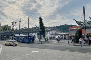 Siegener ZOB im Archiv: leichter Regen und wechselnde Bewölkung vor grauem Himmel über dem Bahnhof.