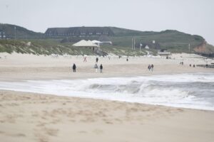 Sylter Strand bei klarem Himmel, sanfte Wellen und entspannte Atmosphäre, ideal für Sommerfrische.