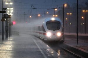 Ein ICE-Zug im Unwetter mit Gewitterwolken, starkem Regen und möglichen Überschwemmungen (Archivfoto).