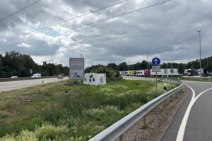 Wohnmobil verunfallt auf der Autobahn 1 bei Stuhr, auf der Seite liegend zwischen Parkplatz und Grünfläche.