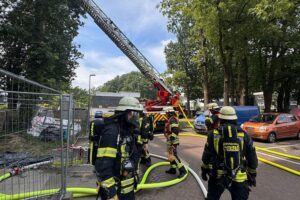 Wohnungsbrand in Erkrath: Feuerwehr im Großeinsatz, Rauch, Rettungsaktion, evakuierte Bewohner, beschädigtes Gebäude.