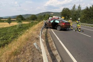 Unfall auf B38: BMW prallt in Leitplanke, Reifen abgerissen, Feuerwehr und Rettungskräfte am Einsatzort.