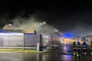 Feuerwehr im Gewerbegebiet bei Brand in Lagerhalle nahe der Messe Friedrichshafen, Löscharbeiten mit vielen Einsatzkräften.
